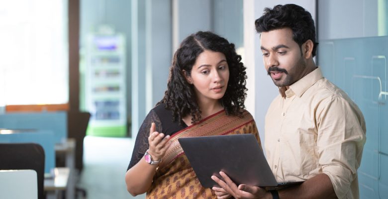 video-two-young-happy-colleagues-using-laptop-communicating-together-coworking-space